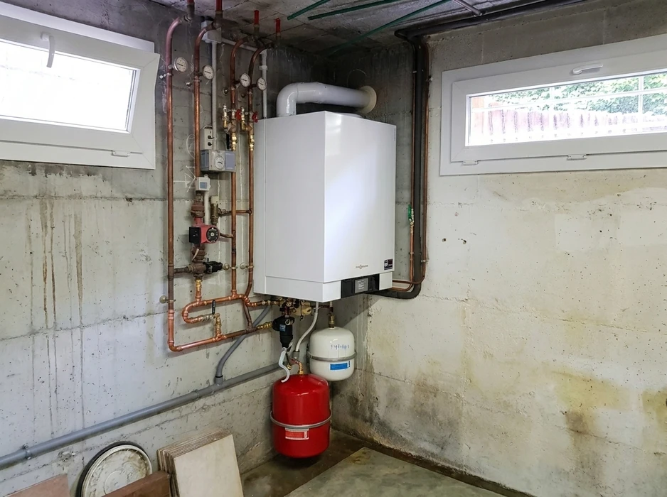 Chaufferie en sous-sol avec chaudière murale à condensation Viessmann Vitodens, raccordée à un réseau de tuyauterie en cuivre