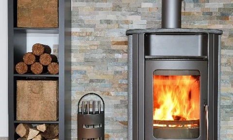 Intérieur résidentiel avec radiateur en fonte blanc installé sous une fenêtre, parquet en bois naturel, murs blancs et encadrement gris