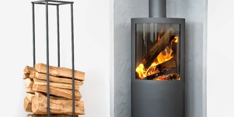 Intérieur résidentiel avec radiateur en fonte blanc installé sous une fenêtre, parquet en bois naturel, murs blancs et encadrement gris