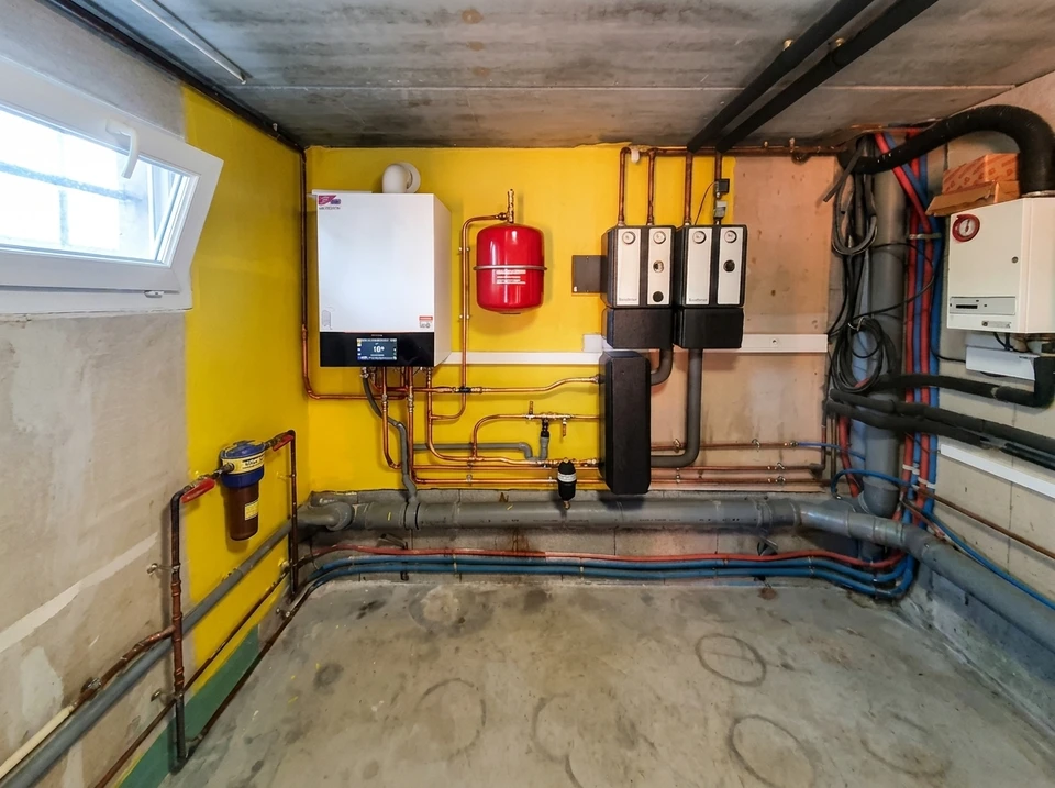 Pompe à chaleur air/eau installée en extérieur, fixée sur un socle béton via un châssis métallique inox