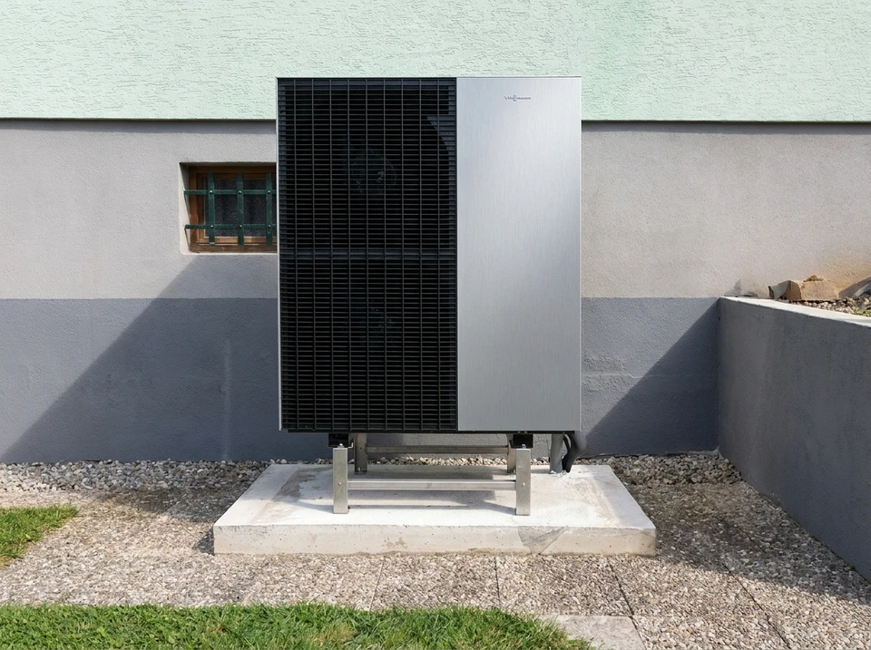 Une pompe à chaleur extérieure est montée sur le mur d'une maison moderne, entourée de plantes luxuriantes de lavande
